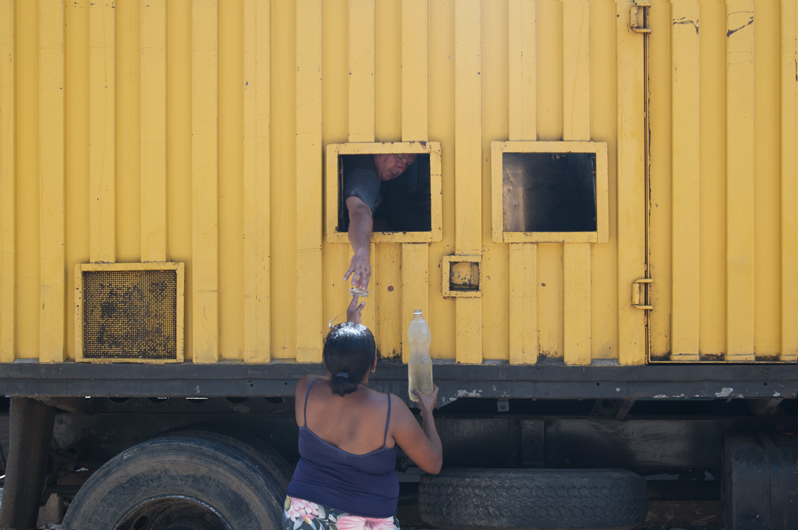 Woman buying from a man inside a truck